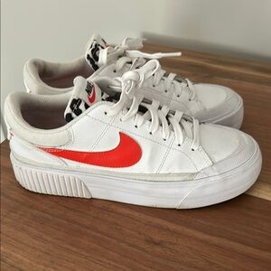 Nike White Sneakers with orange Swoosh